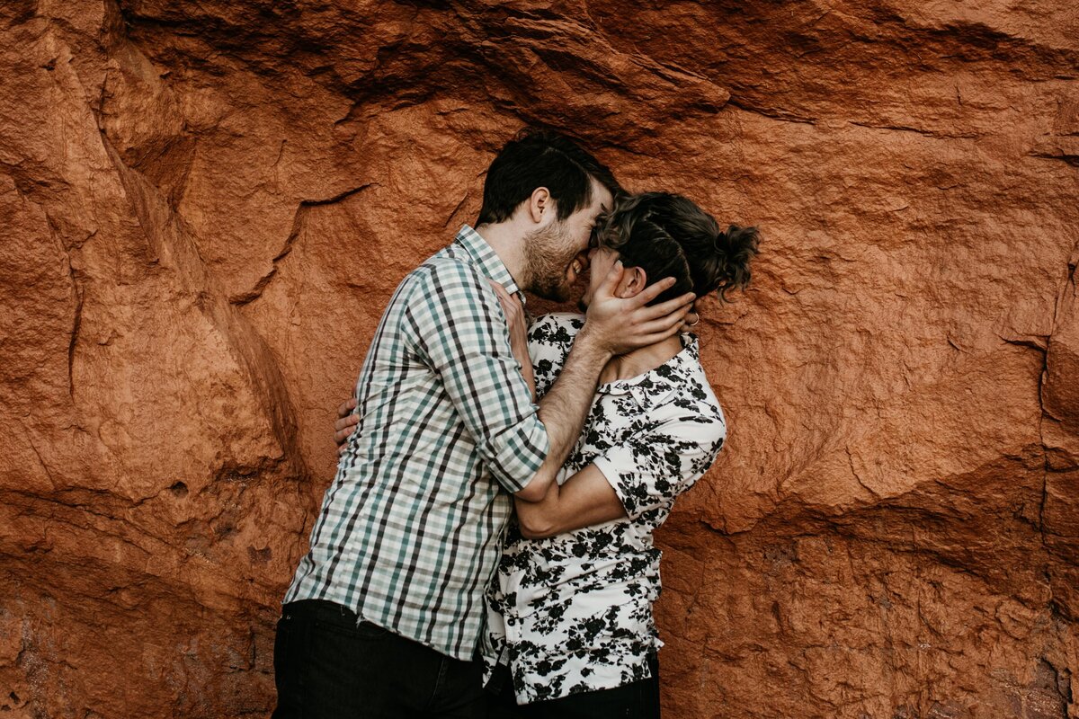 gay couple about to kiss in front of red rock