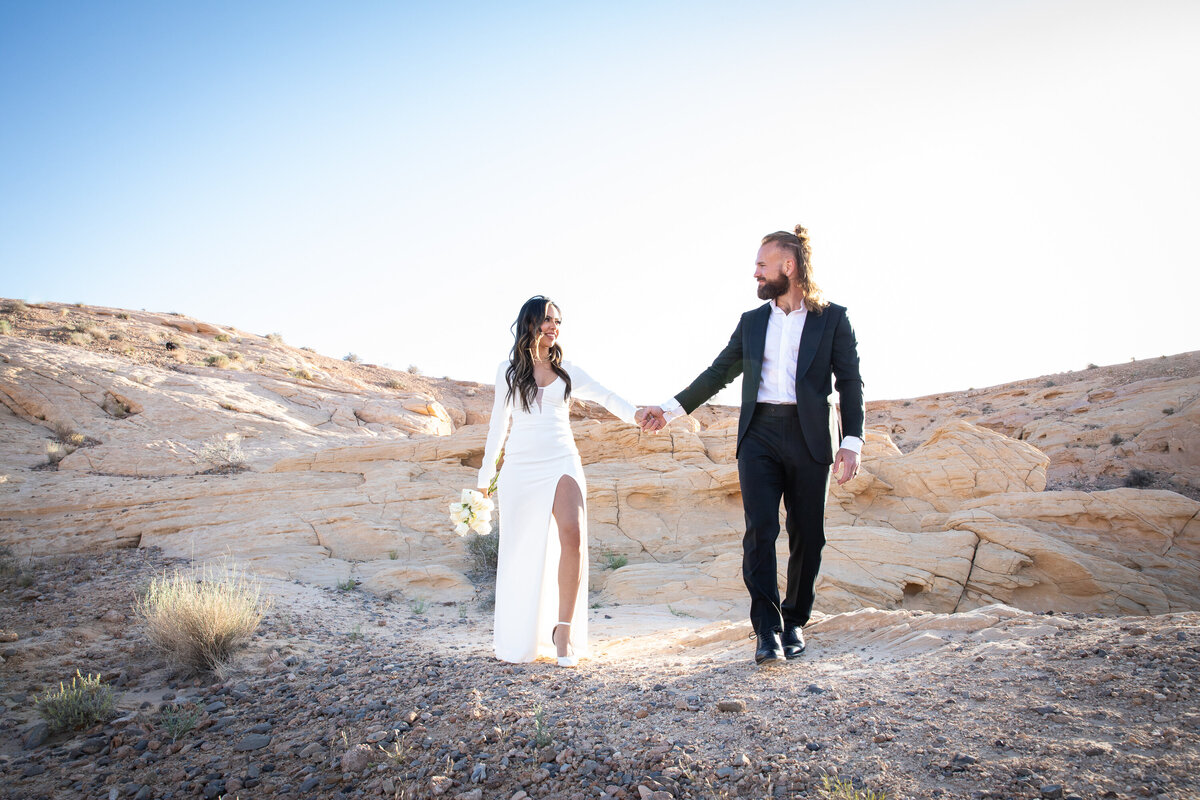 An Austin wedding photographer captures the intimate moment of a bride and groom holding hands in the desert.