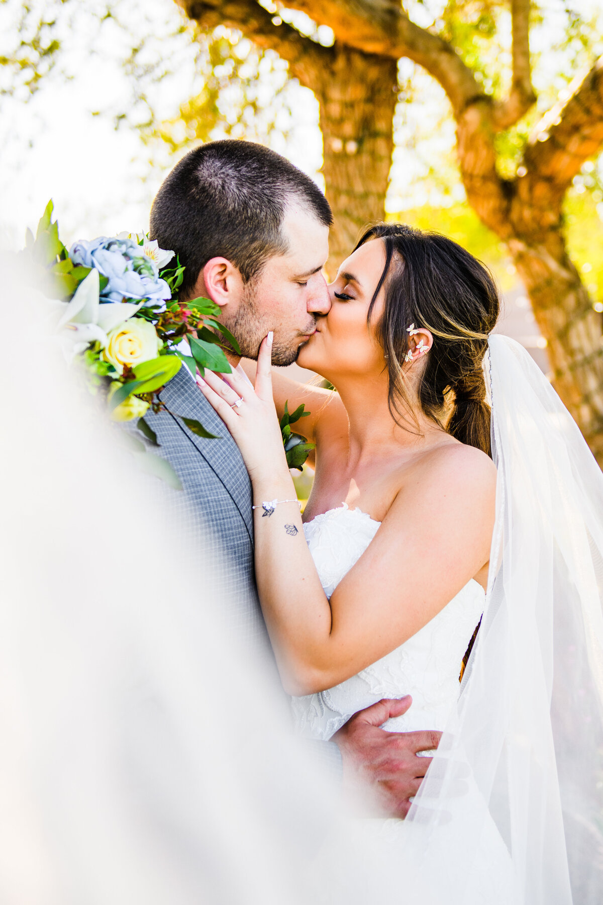 Bride and Groom kissing veil flying Gray Hawk Golf Course Scottsdale wedding