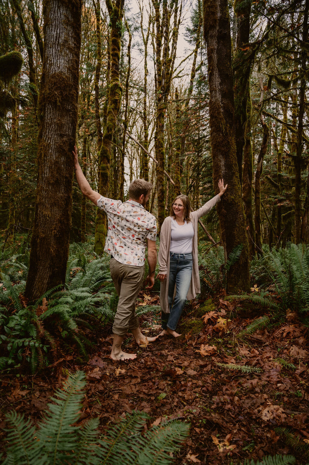 Couple leaning on trees looking at each other in bare feet