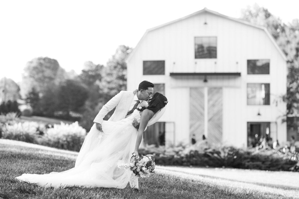 Bride & Groom share a dip and kiss in front of Barn South, Pendergrass GA. 