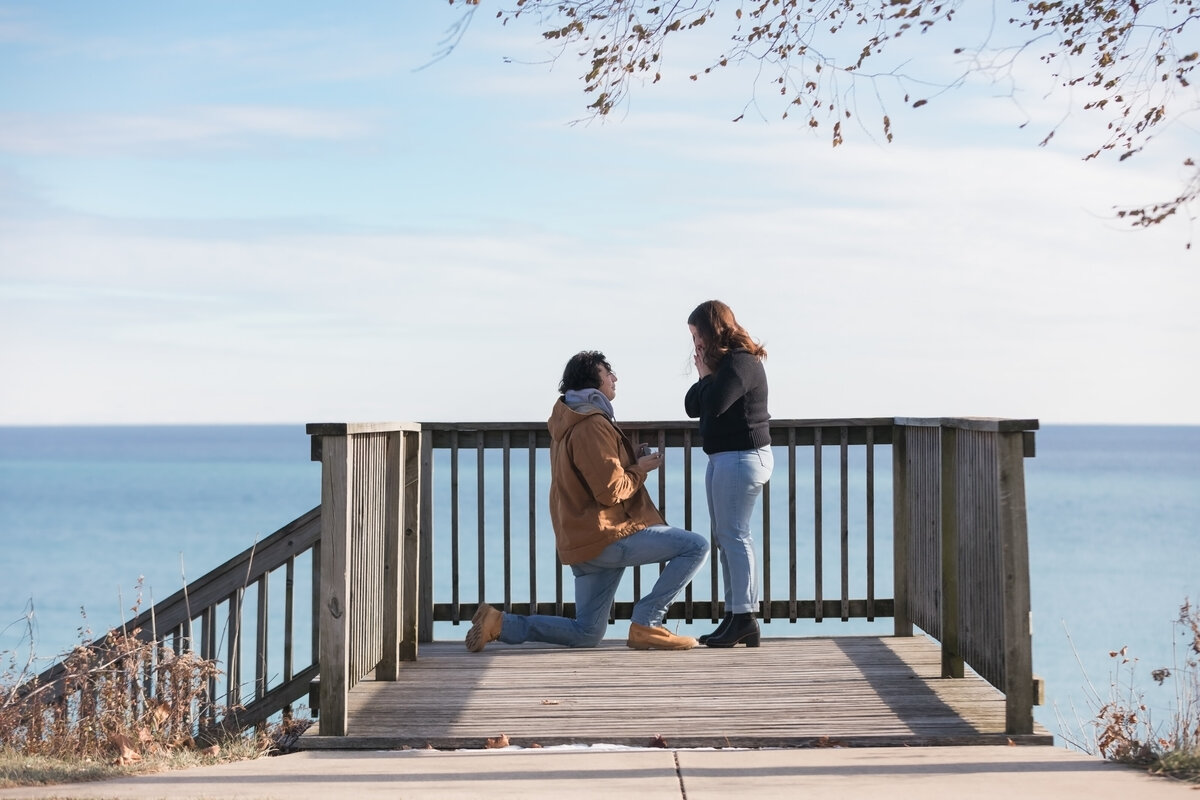 Man is down on one knee proposing to his bride