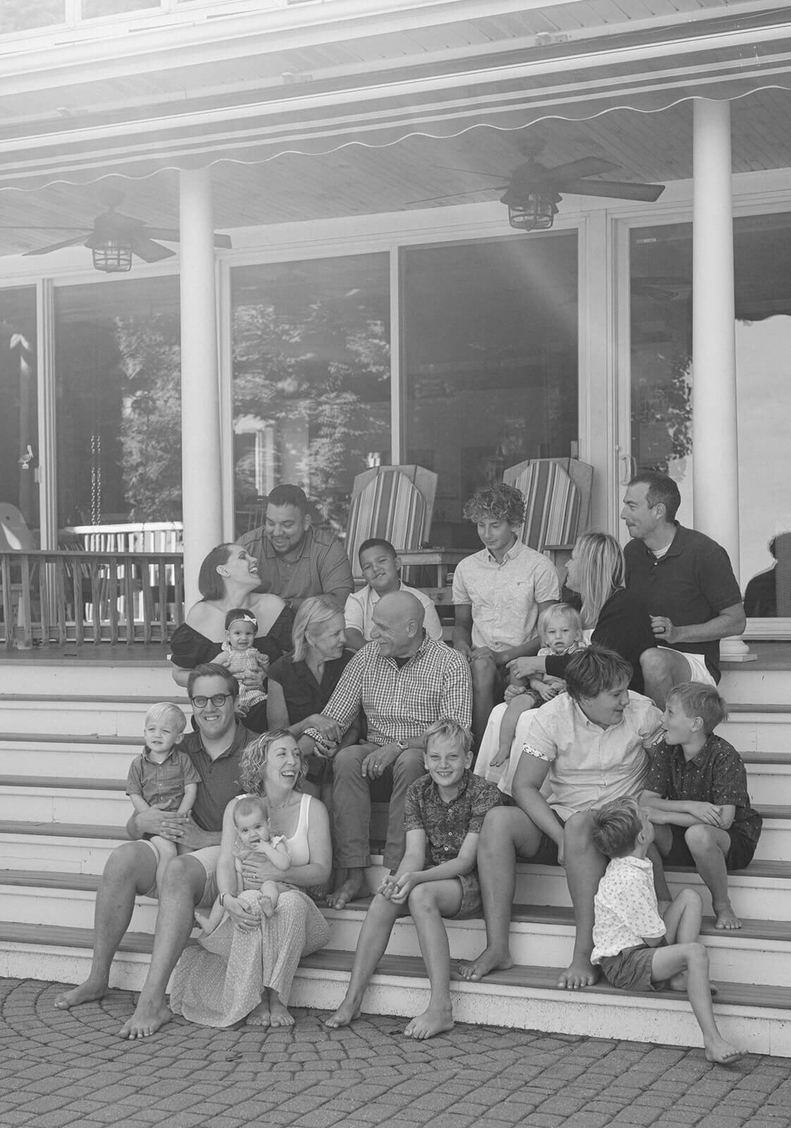 Family sitting on steps of house at generational photoshoot in Finger Lakes, NY