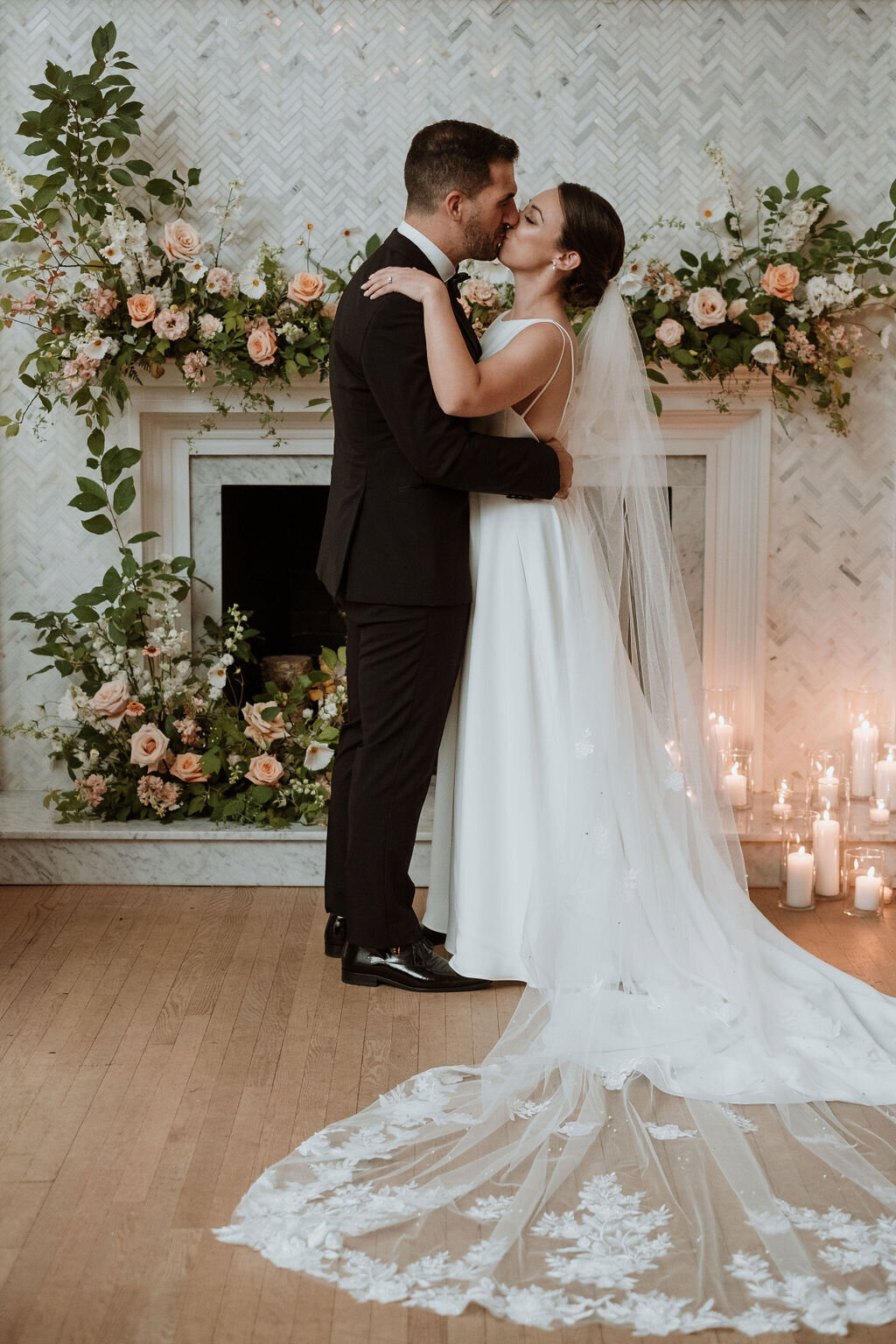 A couple embrace at a wedding at the Atwater Club in front of a meadow of flowers.