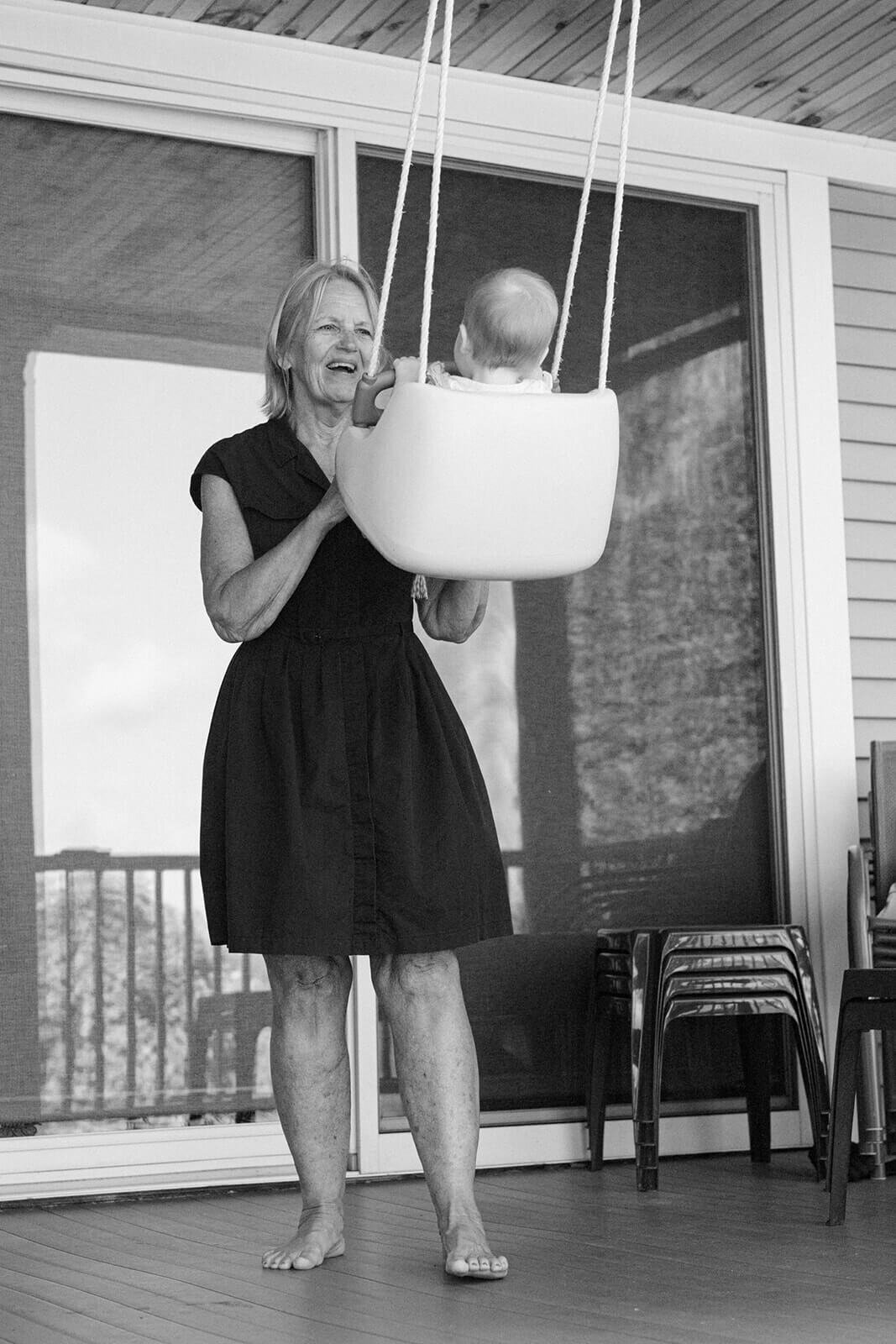 Grandma pushing a baby in a swing