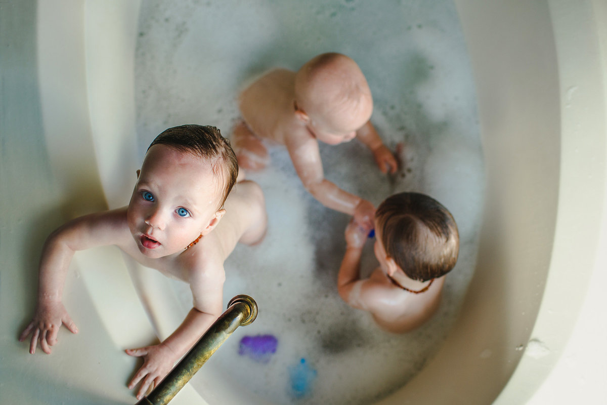 triplets bathing in a tub