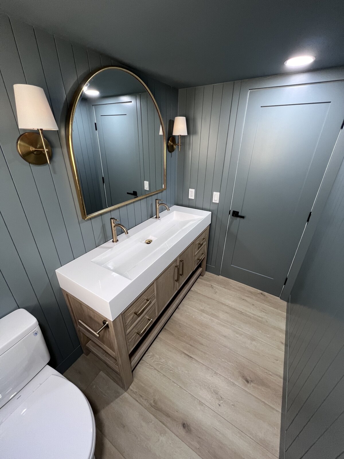 moody-blue-bathroom-arched-mirror-wall-paneling-aw-development