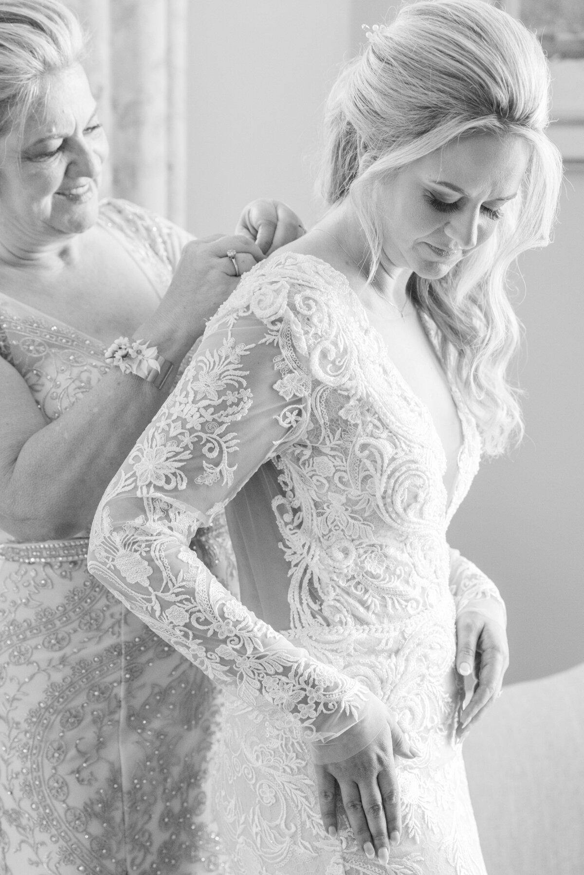 bride getting into her dress with her mom
