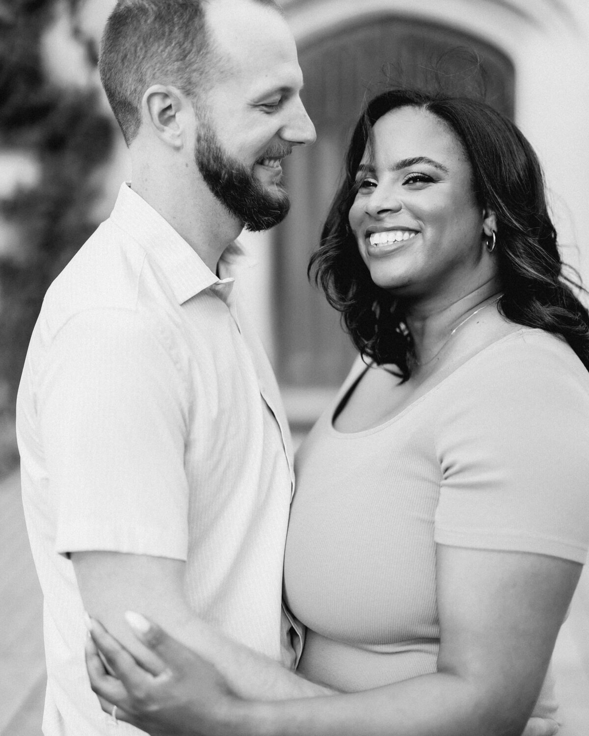 A couple standing chest to chest smiling 