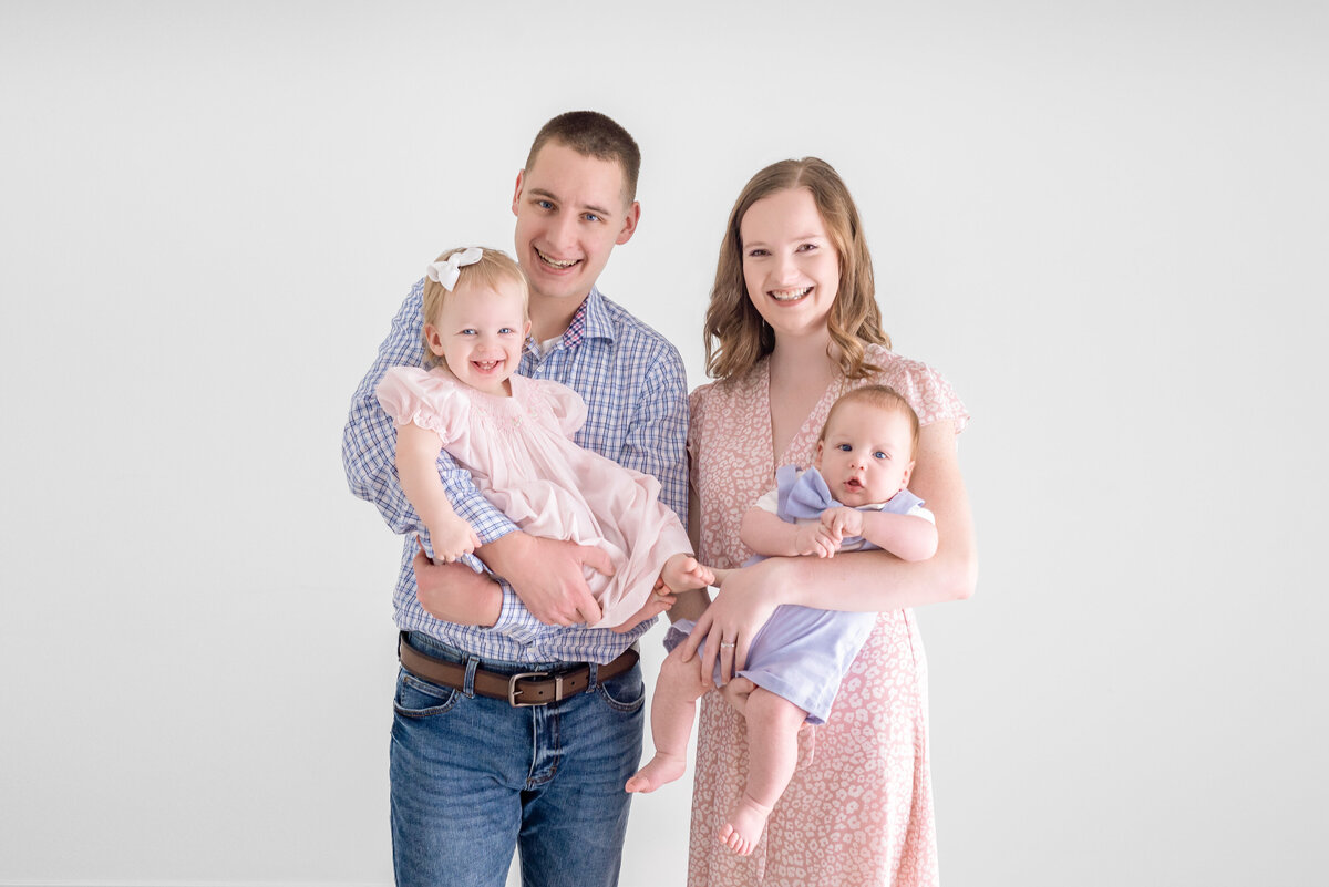 A family of four pose together for family pictures in a studio in Huntsville