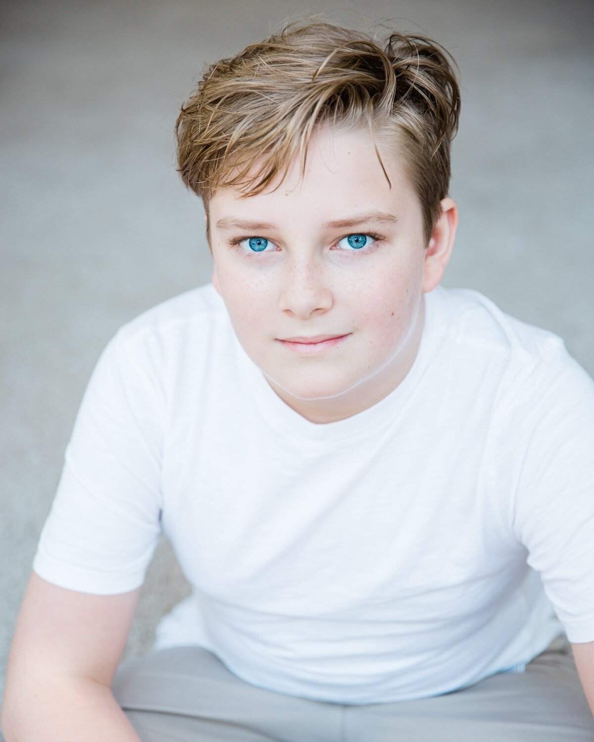Actor headshot of a boy in a white shirt.