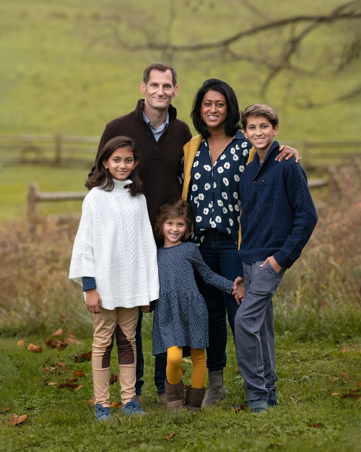 family of five standing in field posing for camera