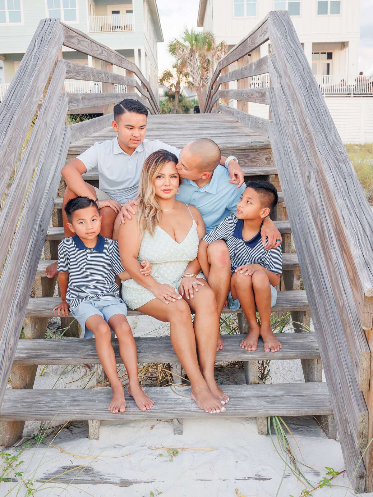 Family sitting close together on the boardwalk steps