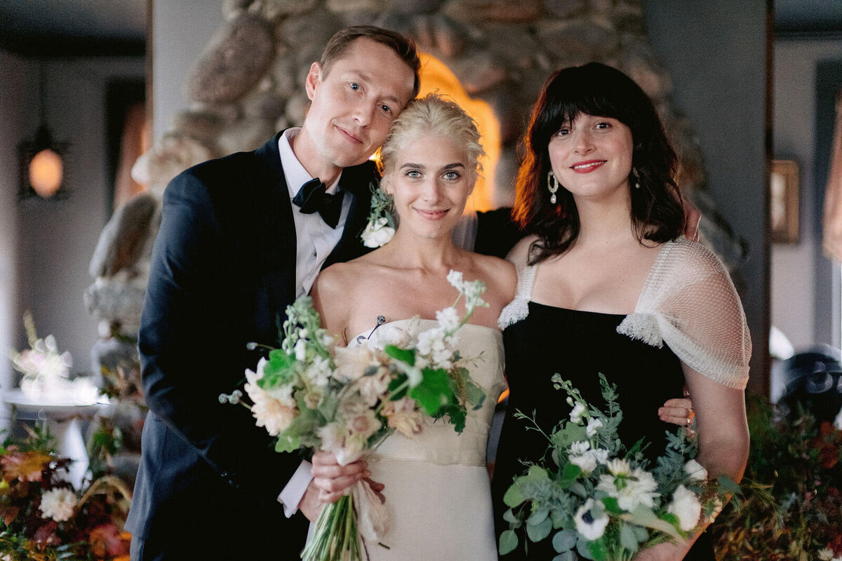 The bride and groom are together with the maid of honor in Foxfire Mountain House, New York. Wedding Image by Jenny Fu Studio