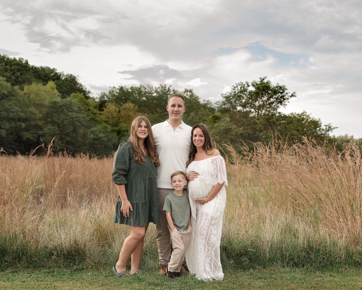 parents and two children hugging in park for family photos
