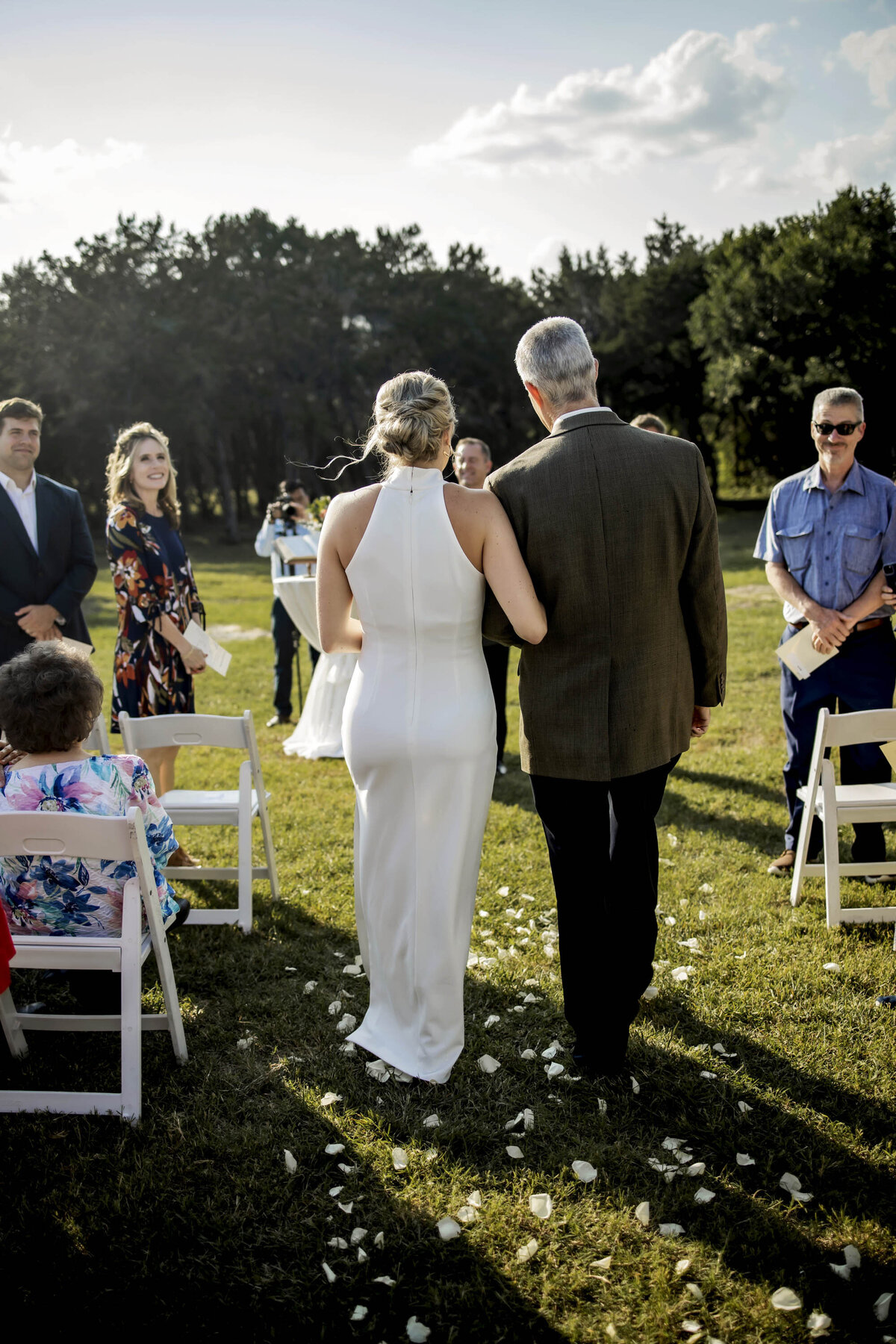 a bride walks down the isle in a small backyard wedding
