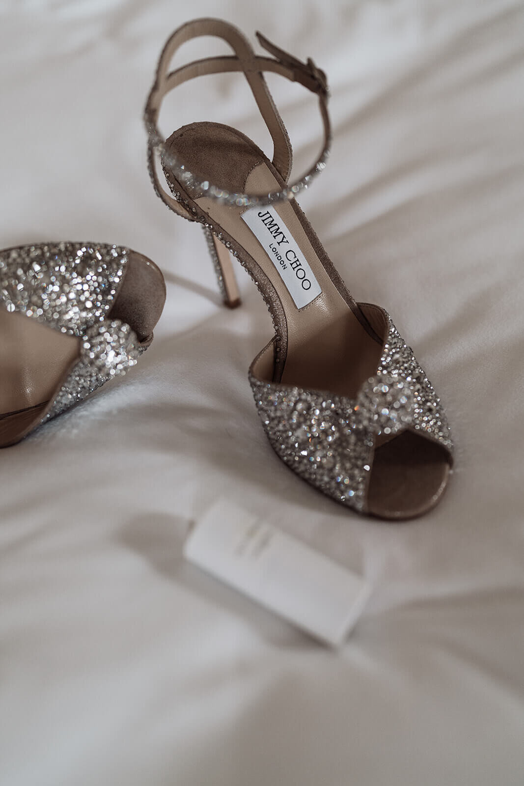 silver glittery jimmy choo wedding shoes displayed in a hotel room at the nomad London before an intimate city wedding