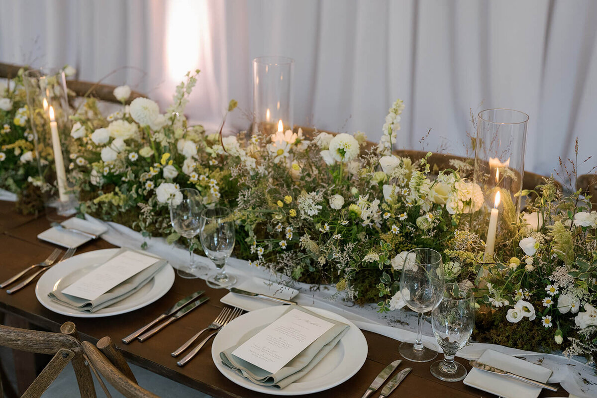 Elegant white tabletop wedding reception design featuring candlelit bouquets of seasonal flowers at the Aspen Meadows Resort wedding reception.