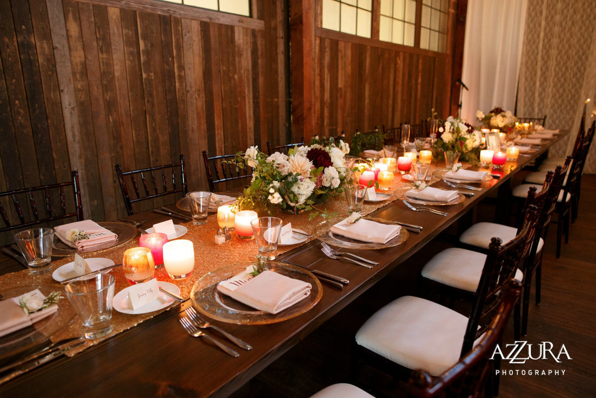long wooden head table in front of wooden barn doors at Sodo Park wedding Seattle