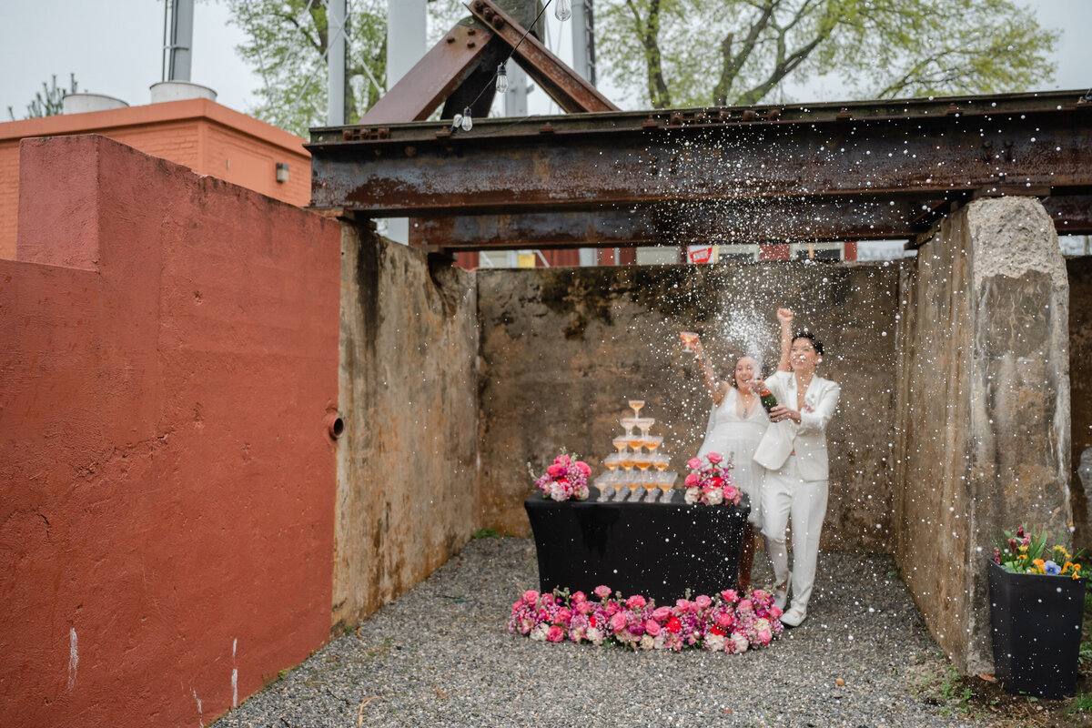Two brides popping champgne