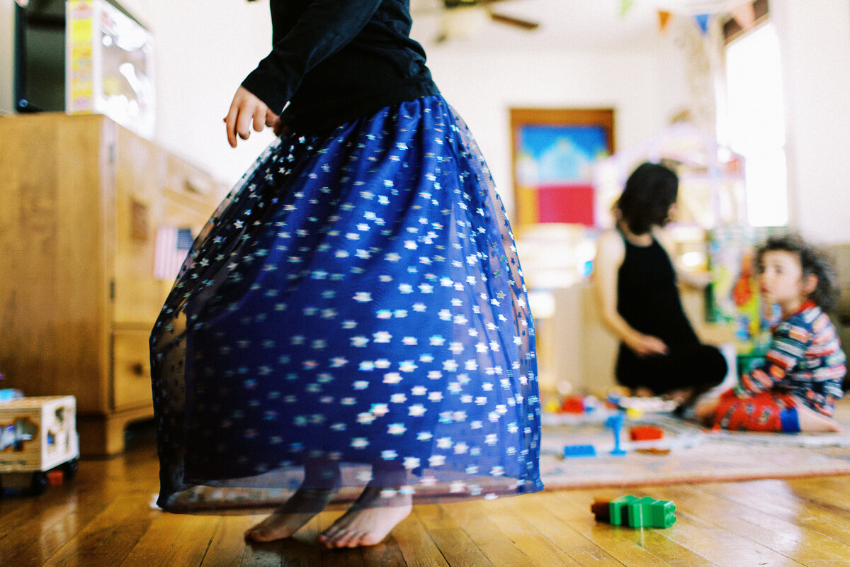 a girl in a purple skirt dances on a wood  floor