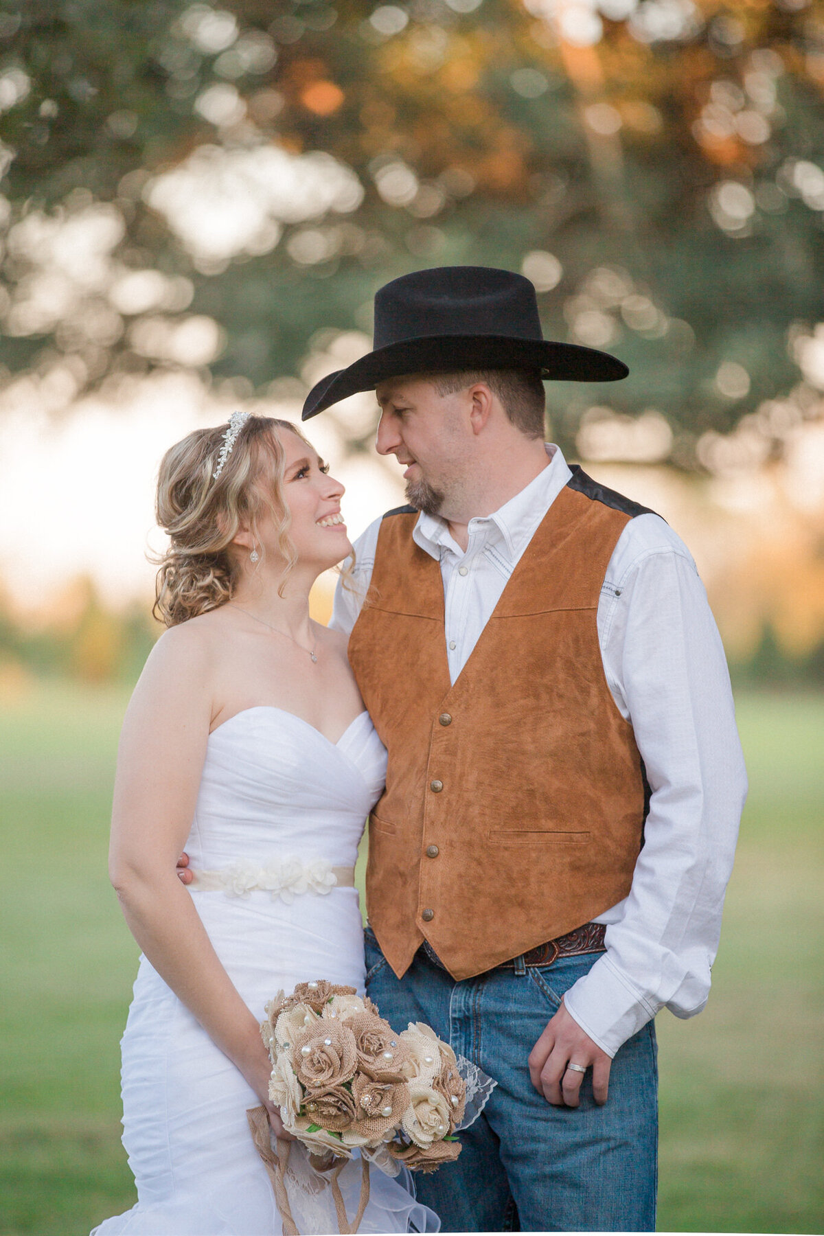 The just married couple smile at each other after their rustic Colorado wedding celebration.
