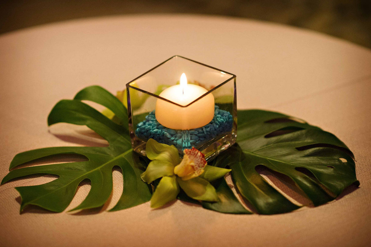 votive candle on monstera leaves tropical theme