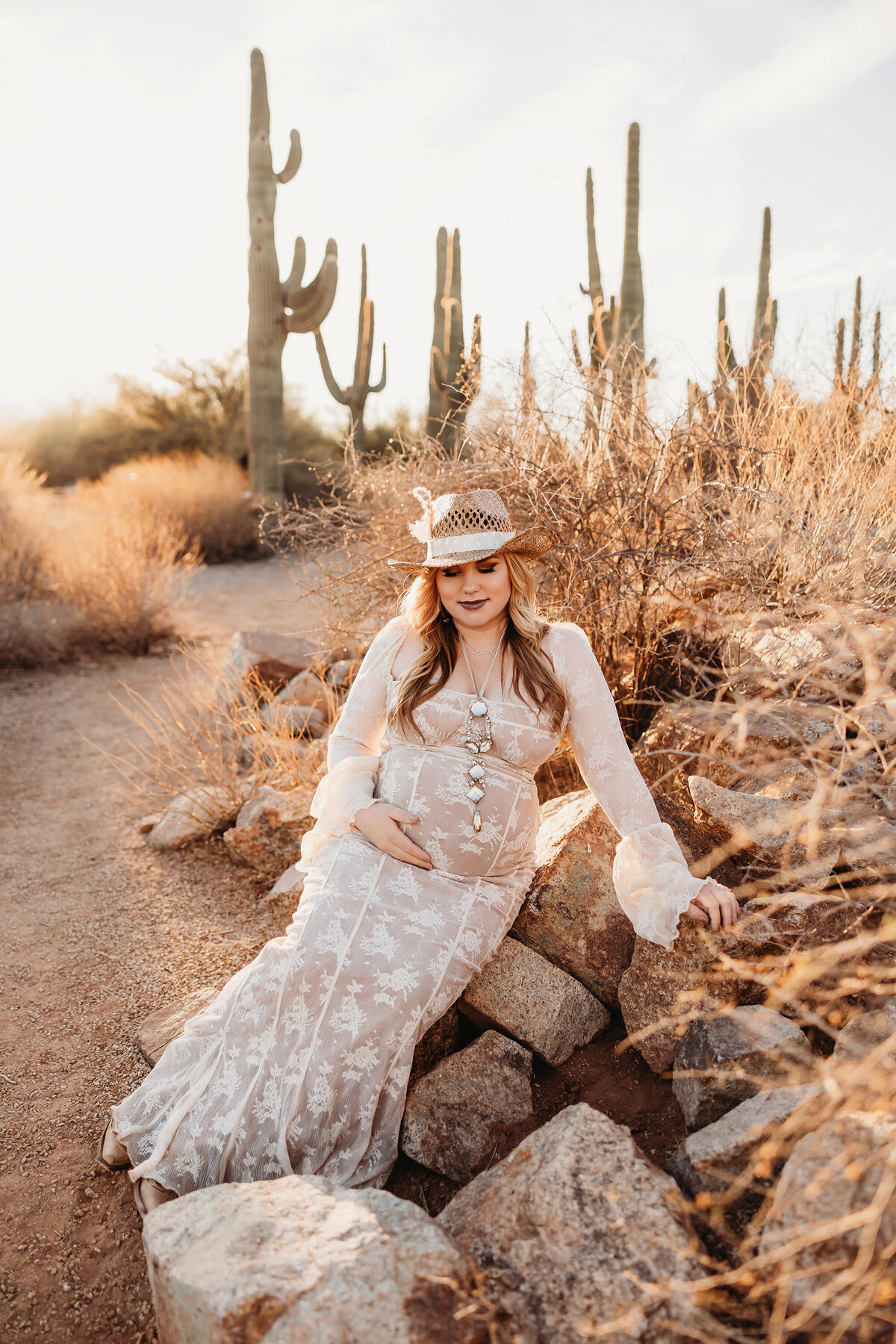 Pregnant mother in lace dress posing for maternity session in arizona