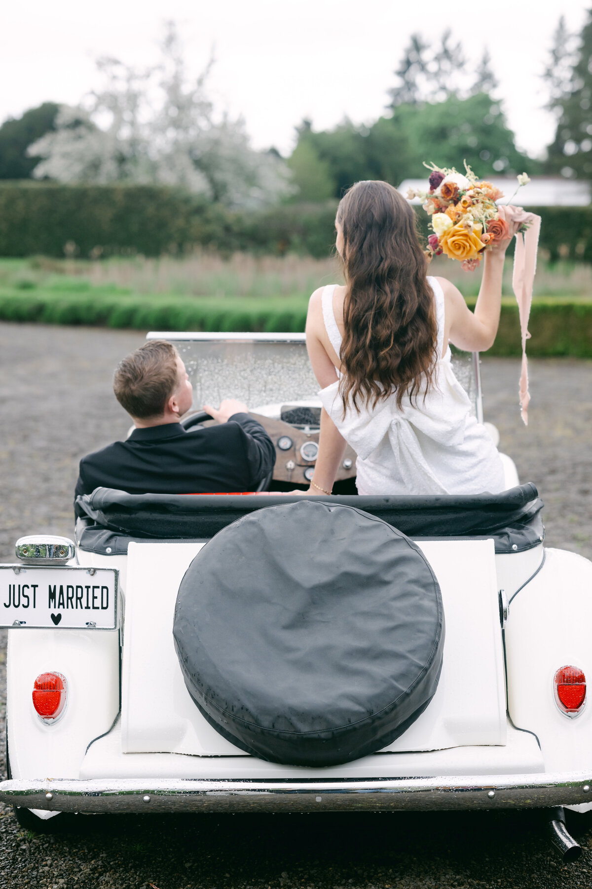 groom driving just married car with bride