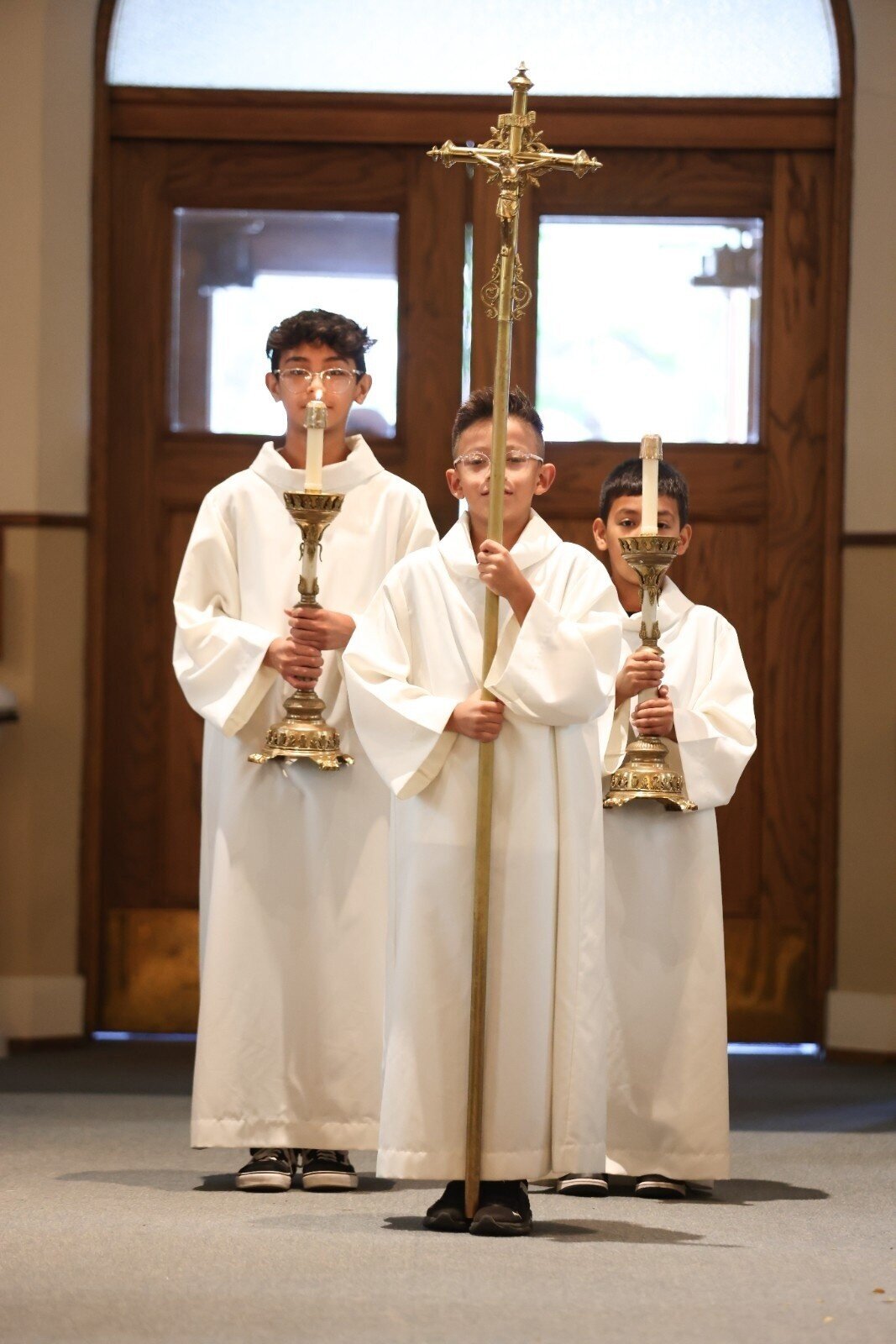 Altar servers lead the ceremony processional with cross and candles at Union Club Hotel wedding.