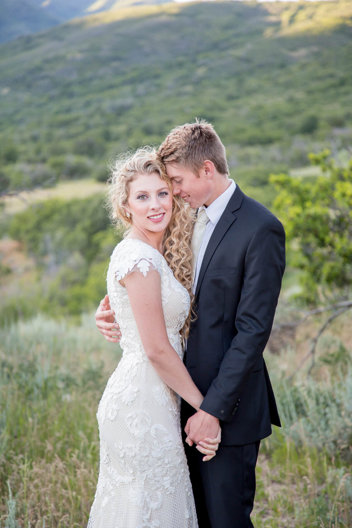 a groom looking at a bride and holding her hand