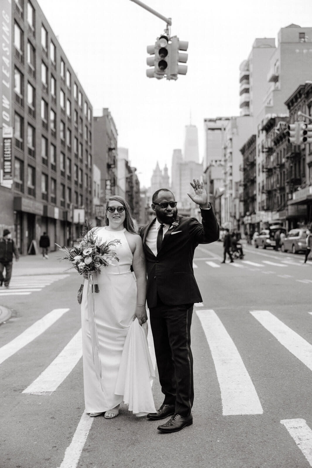Black and white photo of the bride and the groom standing in the middle of a pedestrian lane in New York City.