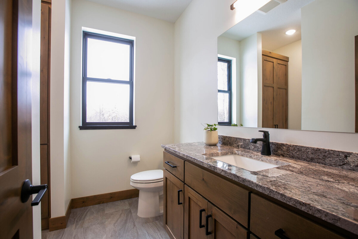 Custom bathroom with dark wood and modern accents in Elk River custom home
