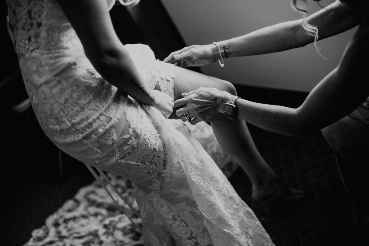 MOM HELPING BRIDE PUT ON HER GARTER