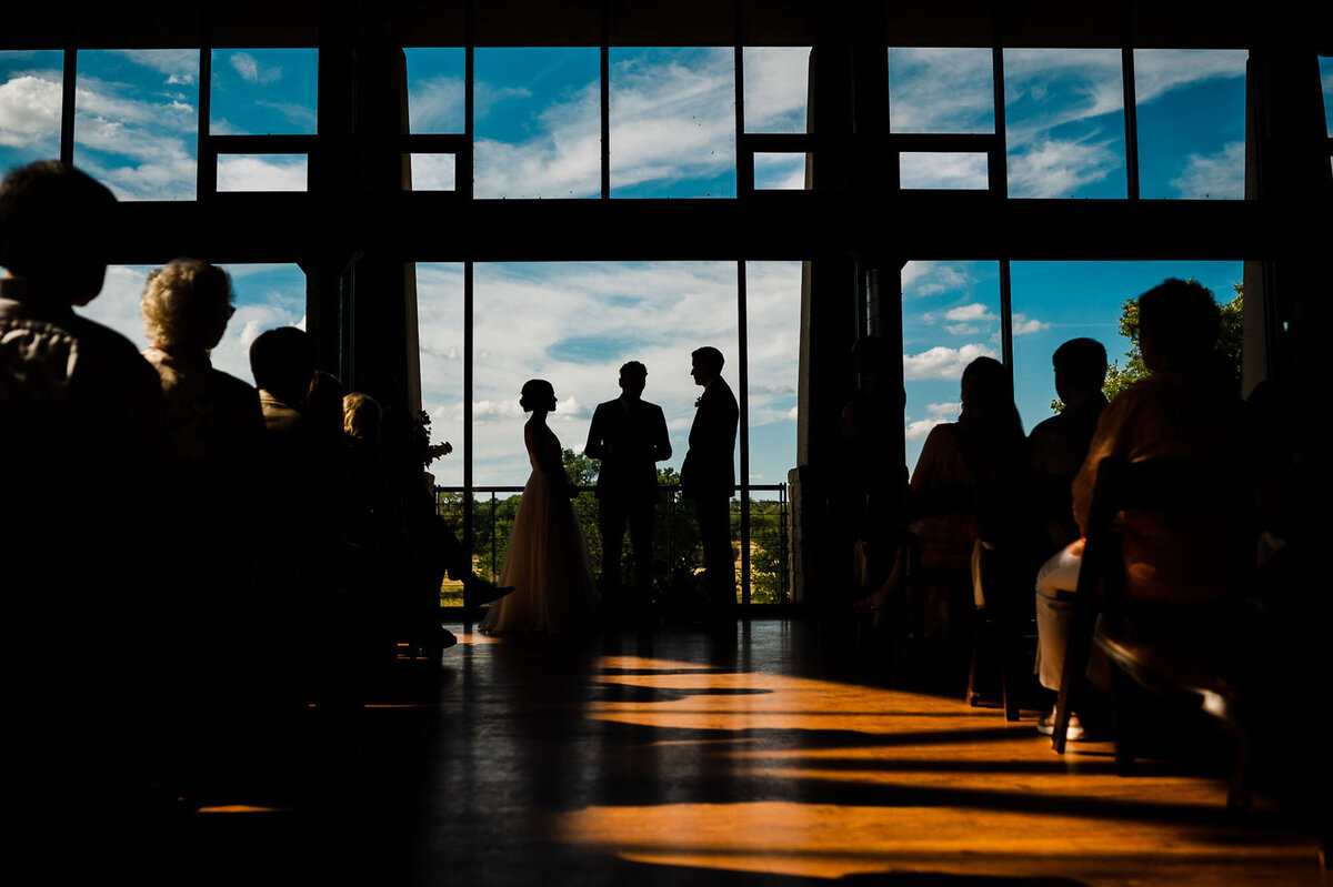 bride wiping a tear away at the end of the aisle at her wedding