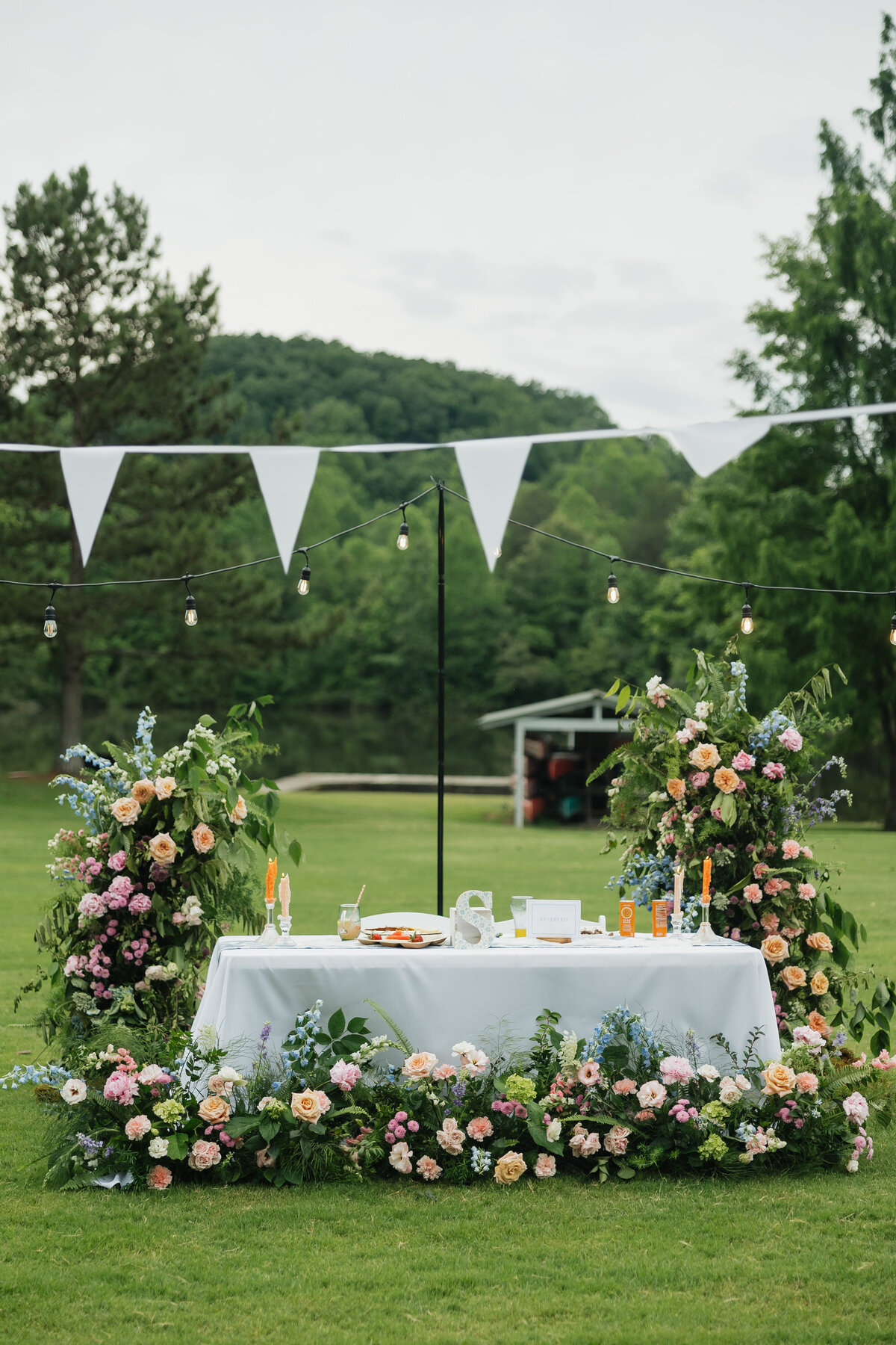 Wedding sweetheart table with colorful floral arrangements designed by Abby Grace Florals at Dahlonega GA wedding