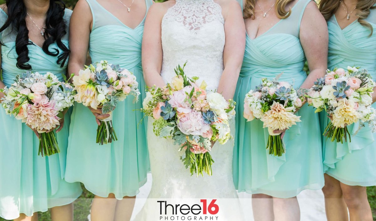 Bride and her bridesmaids pose with their bouquets