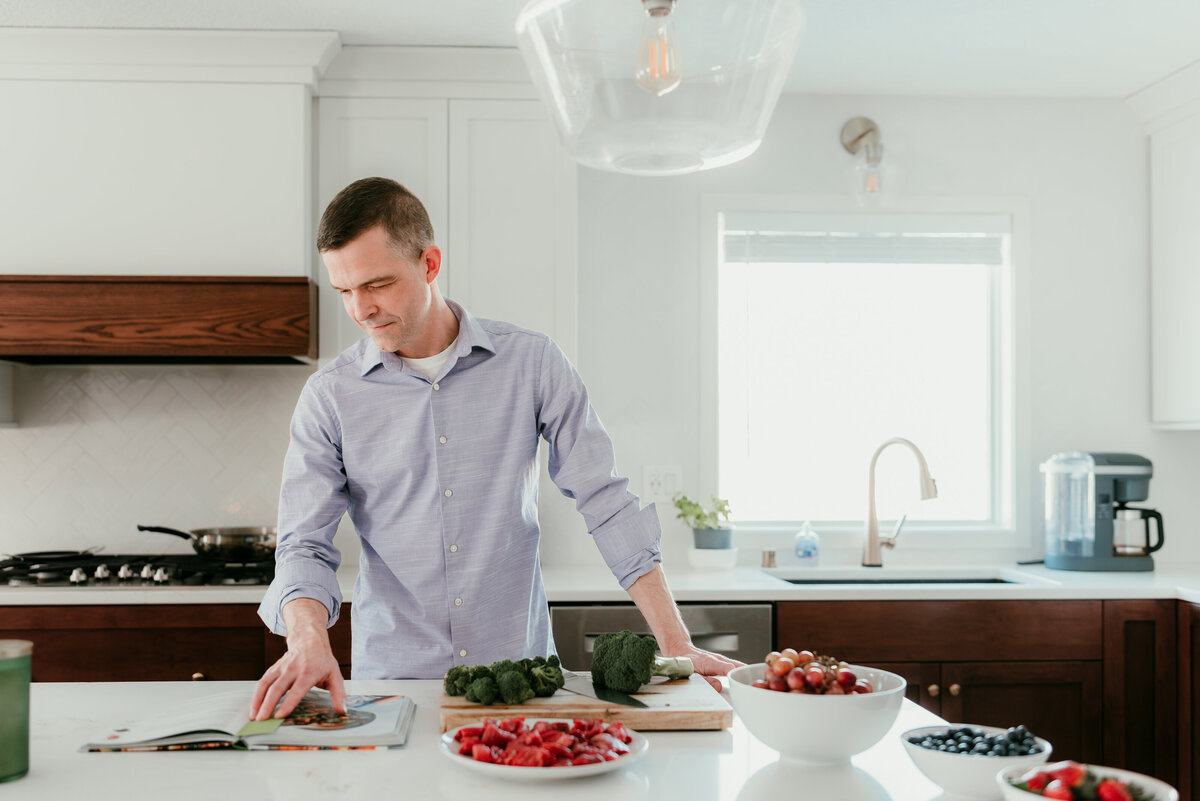 Man preparing food in a contemporary kitchen, emphasizing a warm and genuine vibe for his online dating profile.