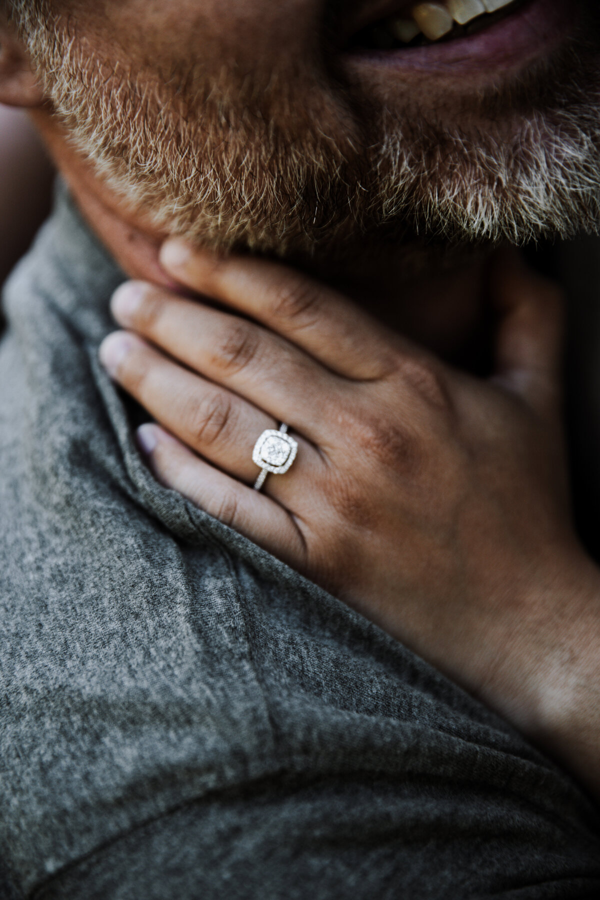 engagement ring detail shot with woman holding her hand on man's shoulder and neck documented by Idaho Falls wedding photographer