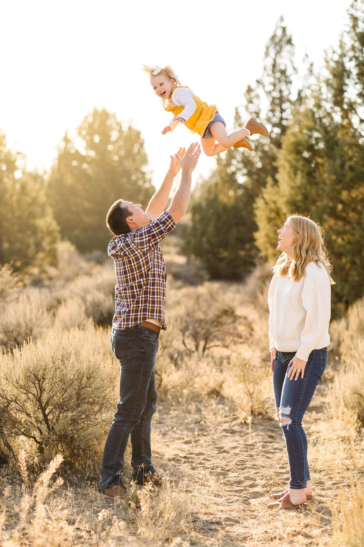 bend-family-photographer-little-blonde-girl-smiling-with-parents-1