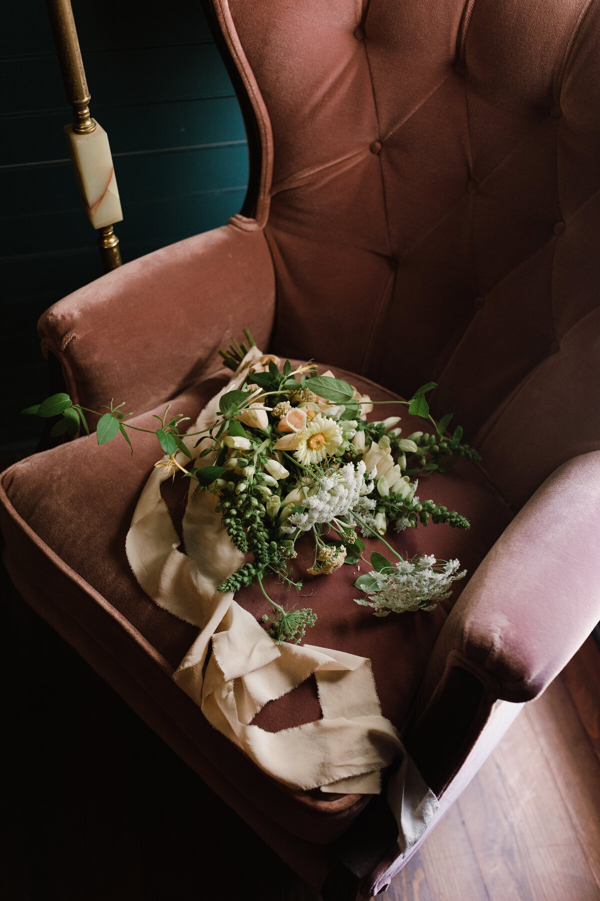 Bride bouquet laying on a velvet pink chair