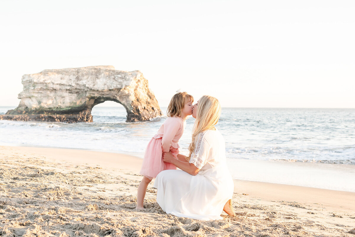 mother and daughter kissing at Natural Bridges Beach in Santa Cruz