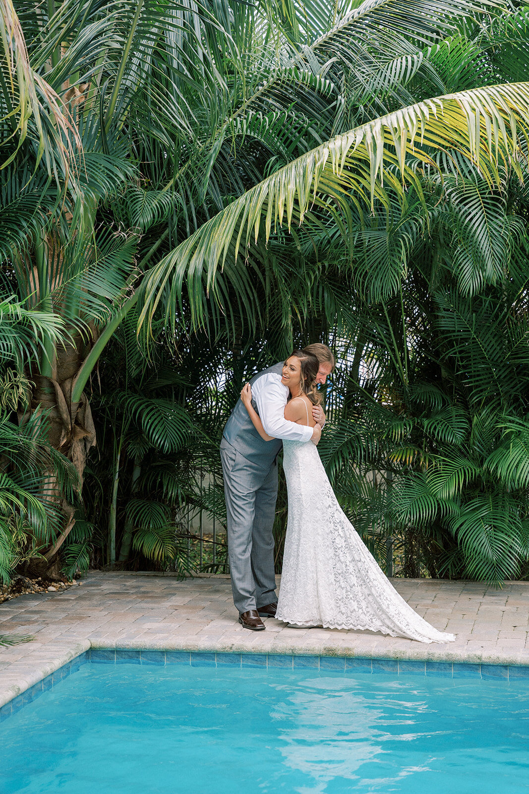 bride and groom hugging under palm trees