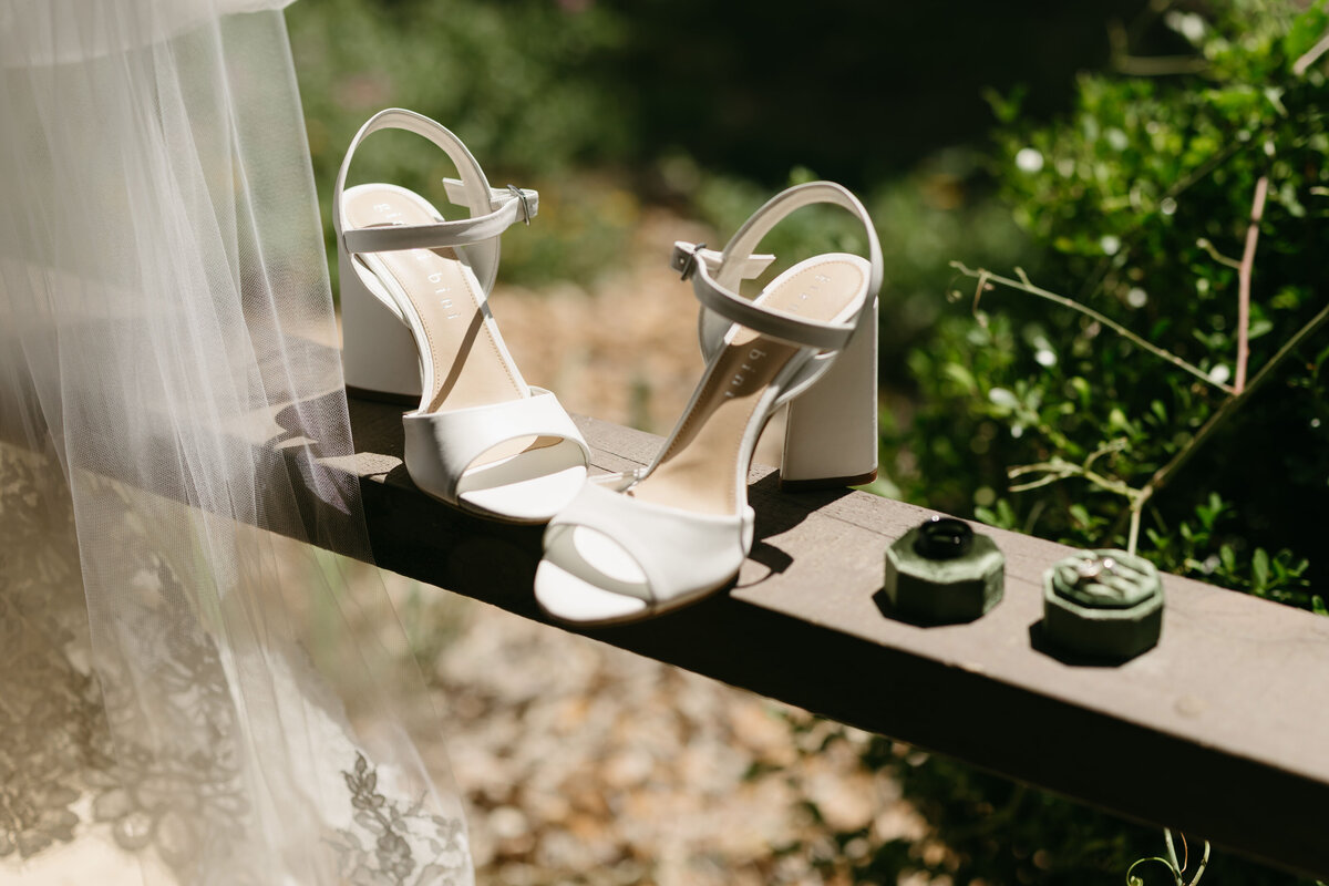 wedding shoes for bride sitting on rail outside in austin texas