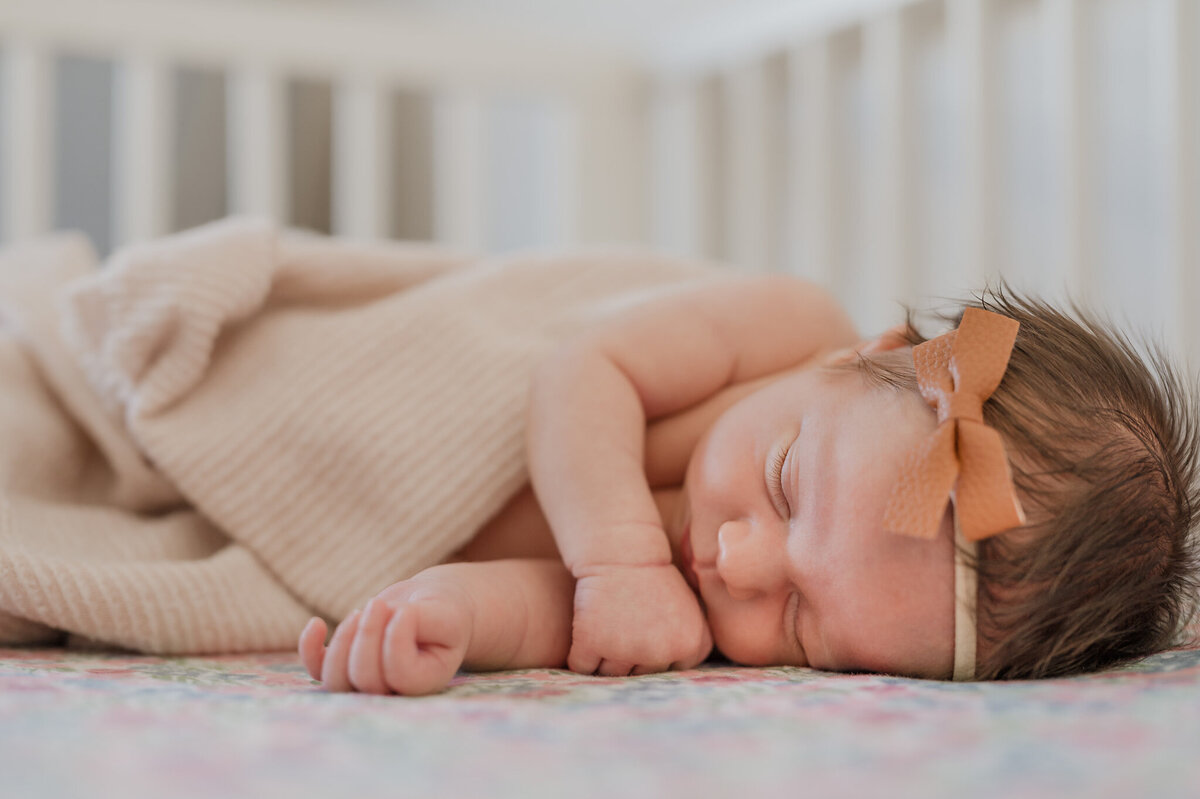 Baby girl asleep in her crib during San Antonio newborn photography in-home.