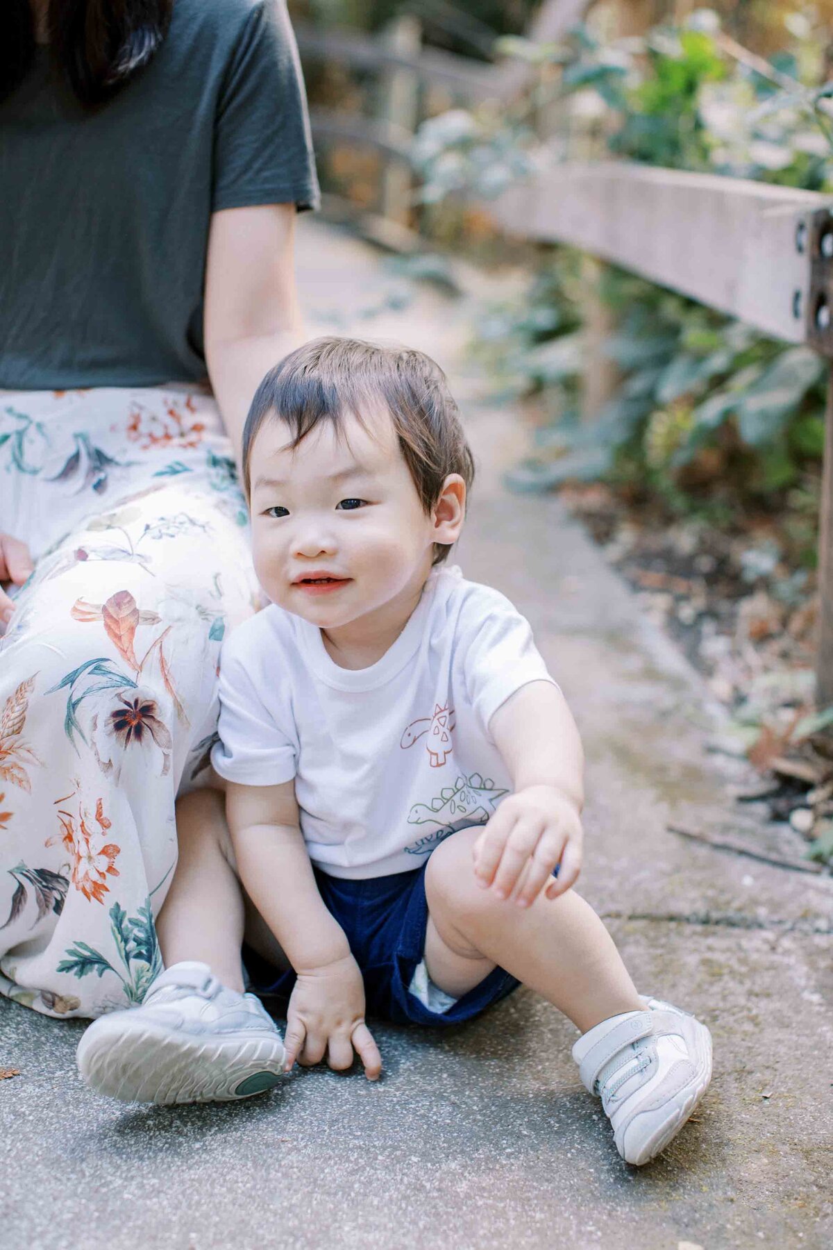 boy sitting on ground next to mom