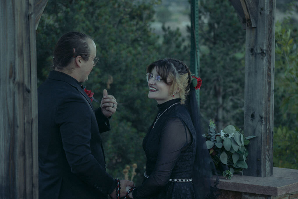 A newlywed couple smiling at each other.