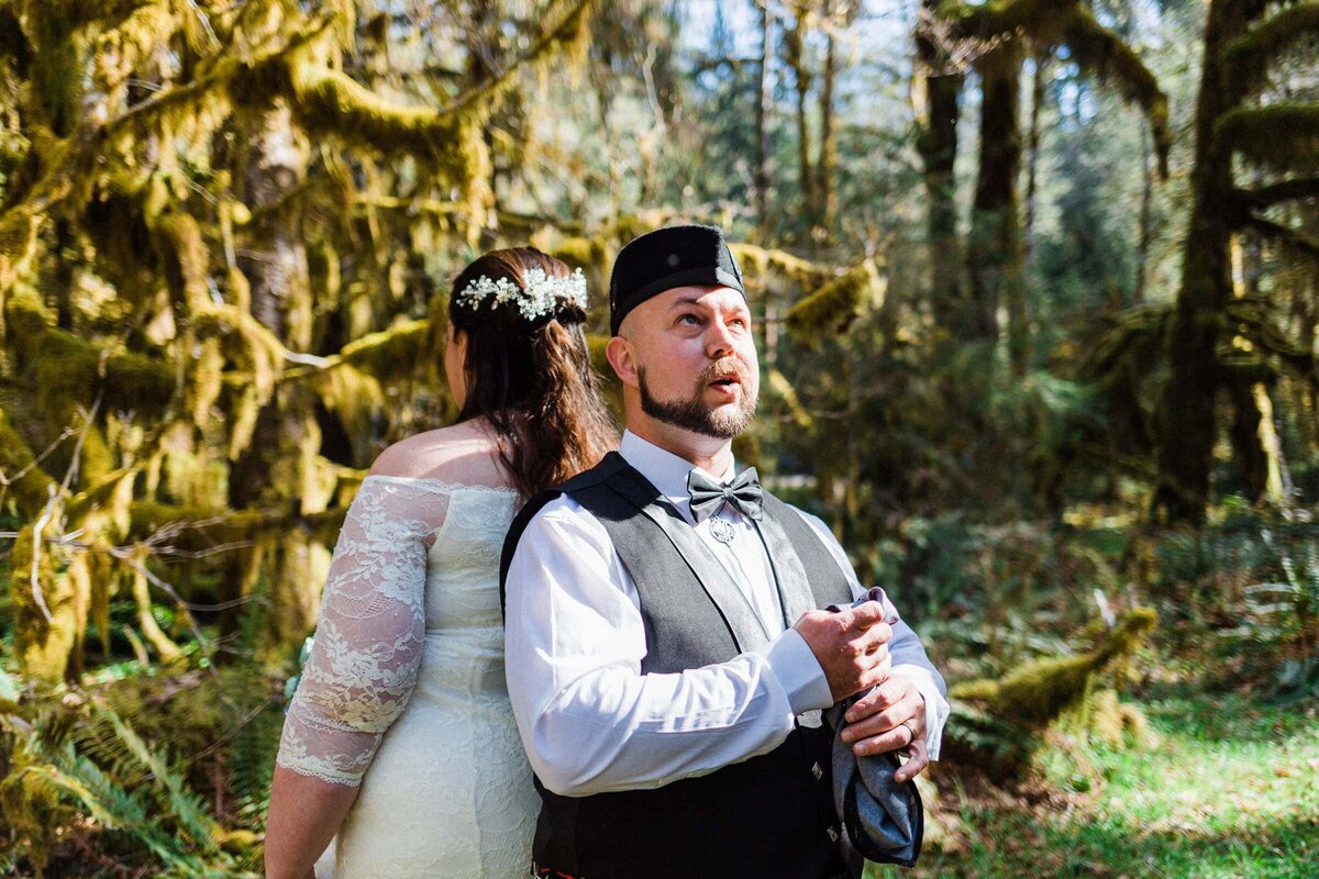 A groom in awe at the dangling moss during the first look at his Hoh Rainforest Elopement. 