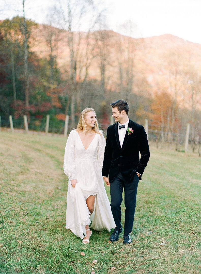 Bride and Groom Walking Toward Camera Holding Hands at Asheville Wedding