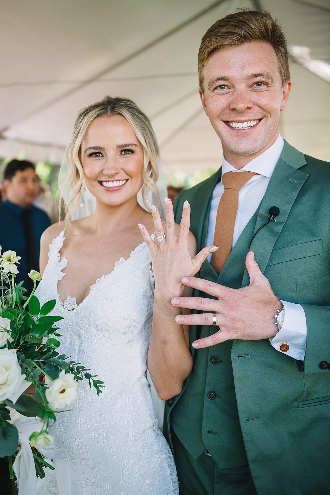 Bride and groom show off their wedding bands on their wedding day.